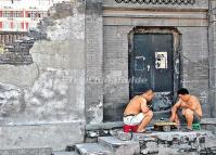 Two Men Are Playing Chinese Chess in A Beijing Hutong