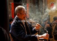 An Old Man is Sucking at His Pipe in a Chengdu Teahouse